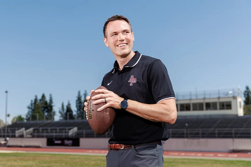 Coach AJ Parnell holding a football