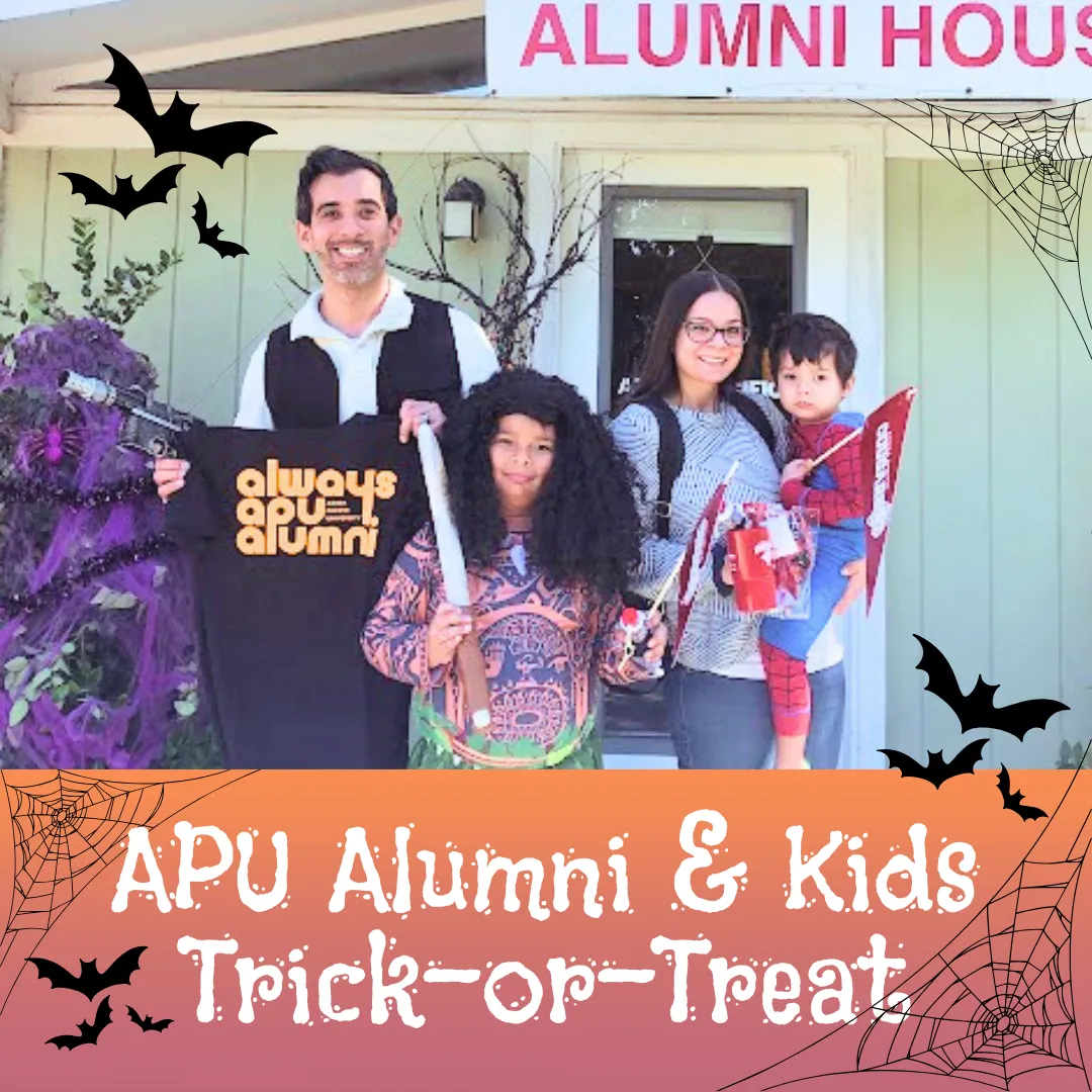 family in front of the alumni house wearing customes