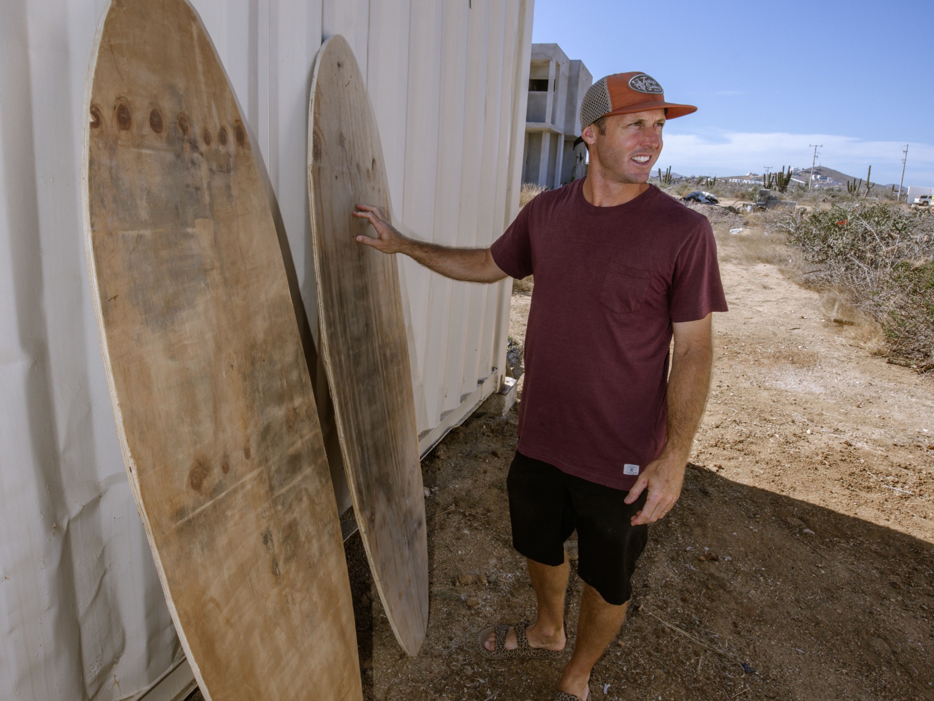 Man stands by 2 surfboards