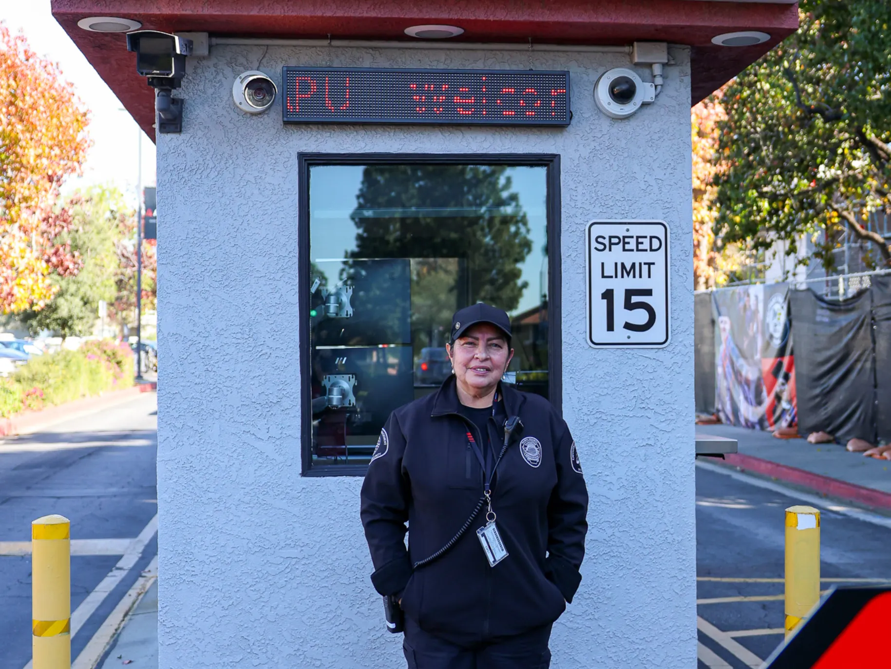 Campus Safety officer stands before surveillance booth.