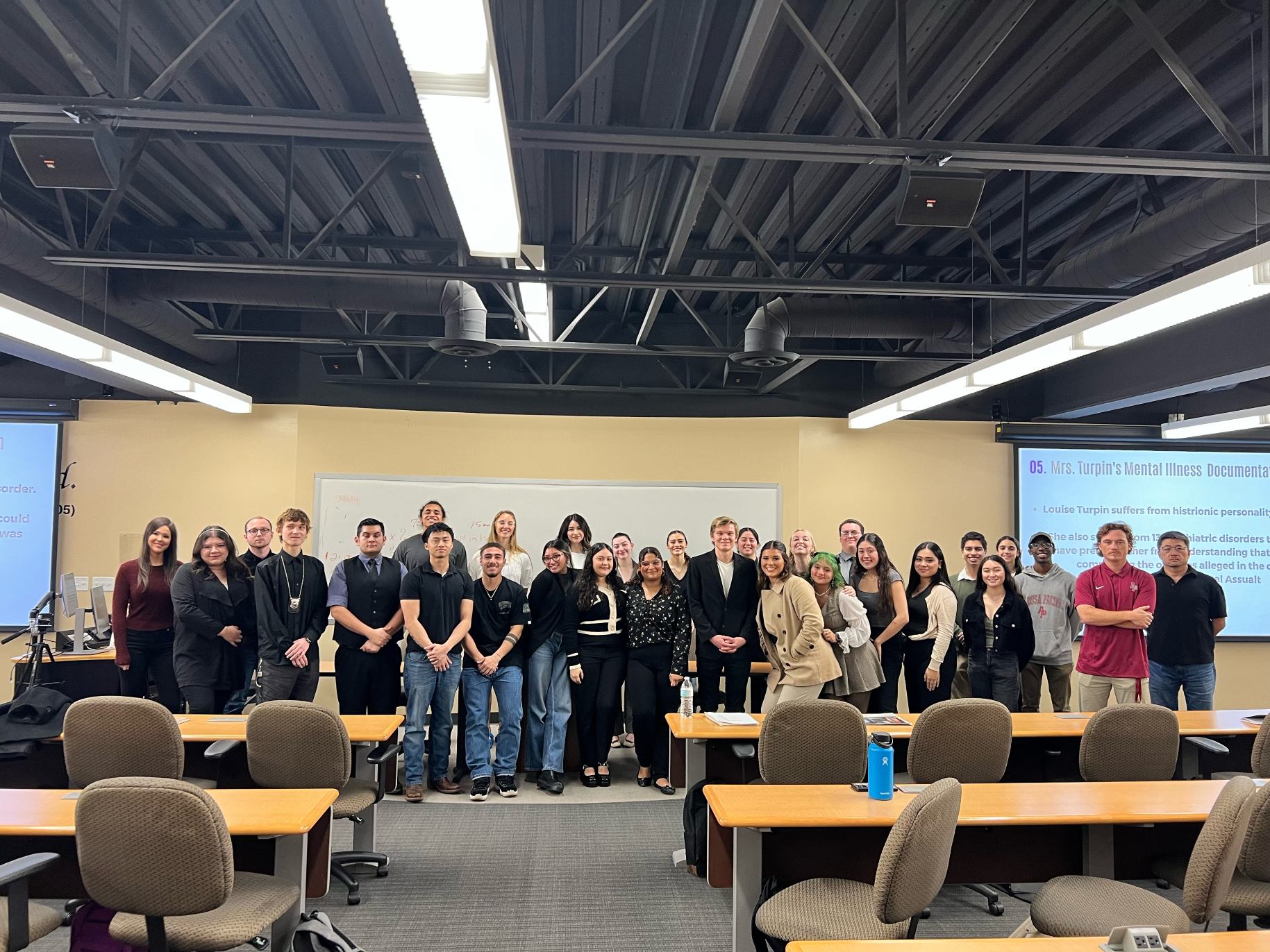 Criminal Justice students stand together in a classroom after a mock trial.