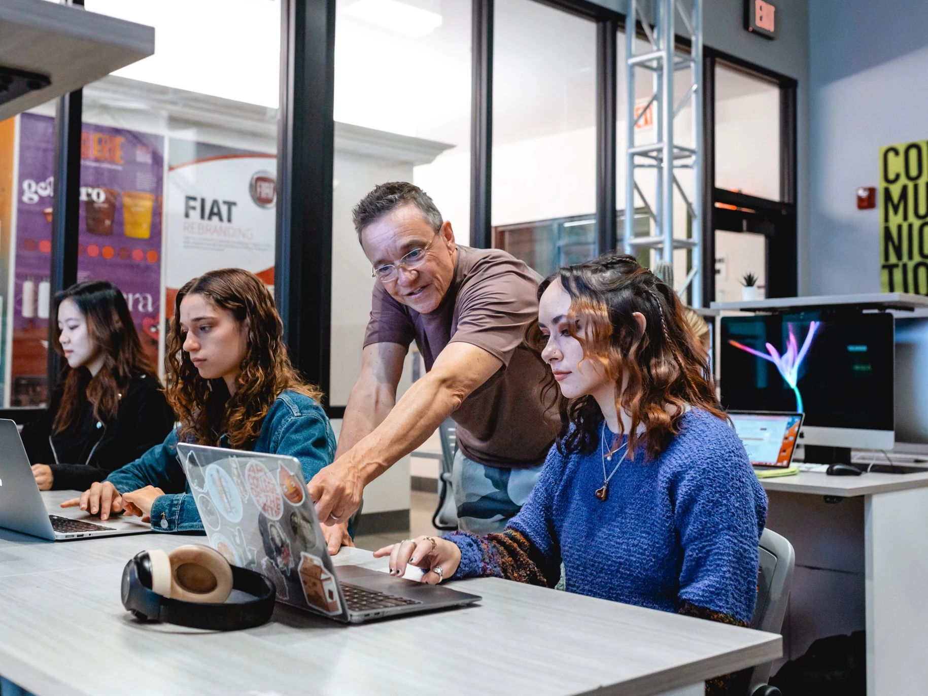 A professor gives guidance to a student on her project