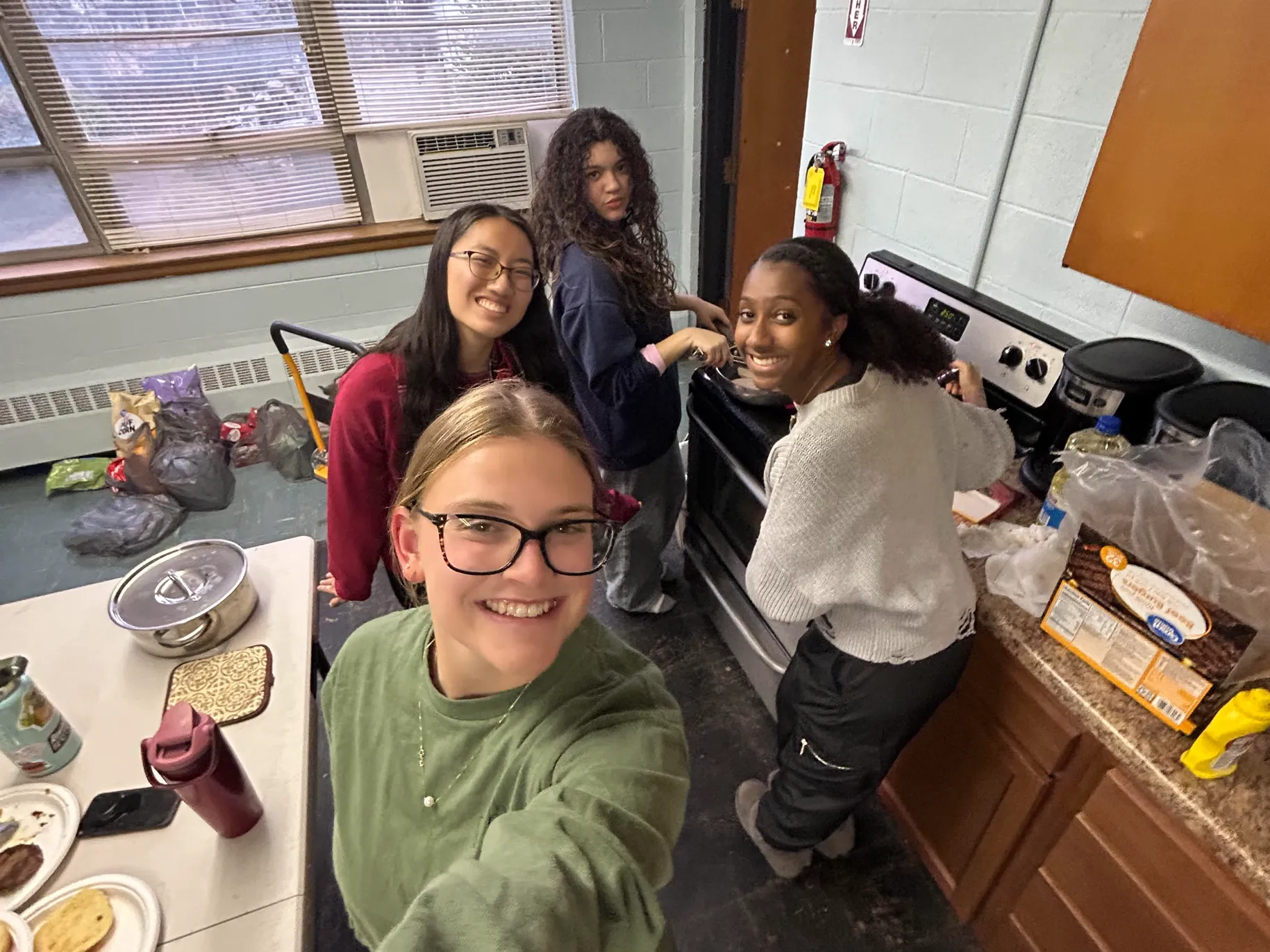 Kaylee Gunnoe ’26 and friends standing in kitchen.