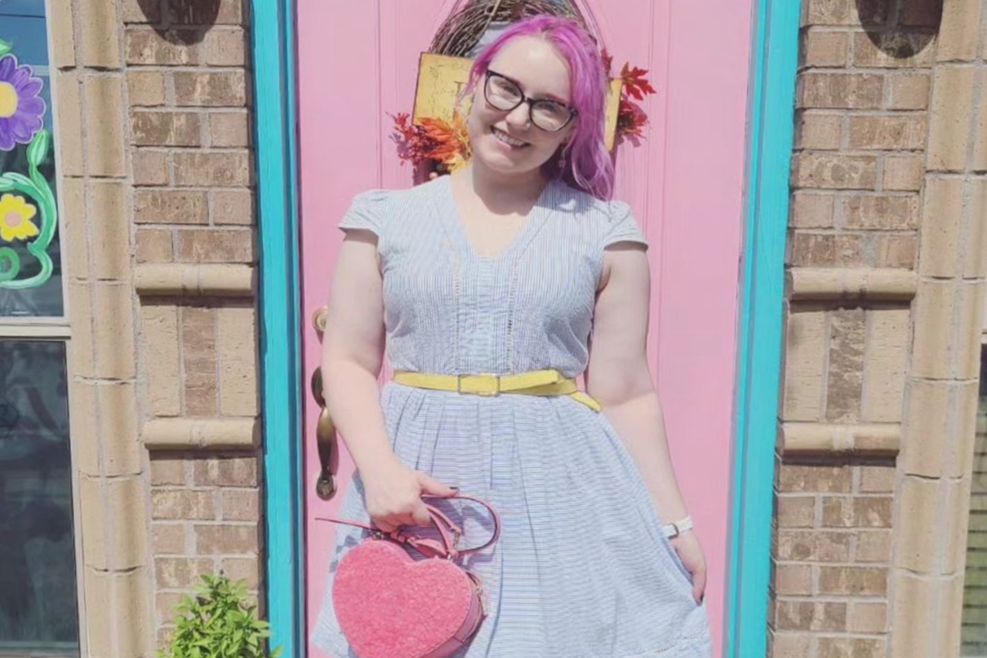 Kelsey smiles in a flowy dress outside a storybook-like house