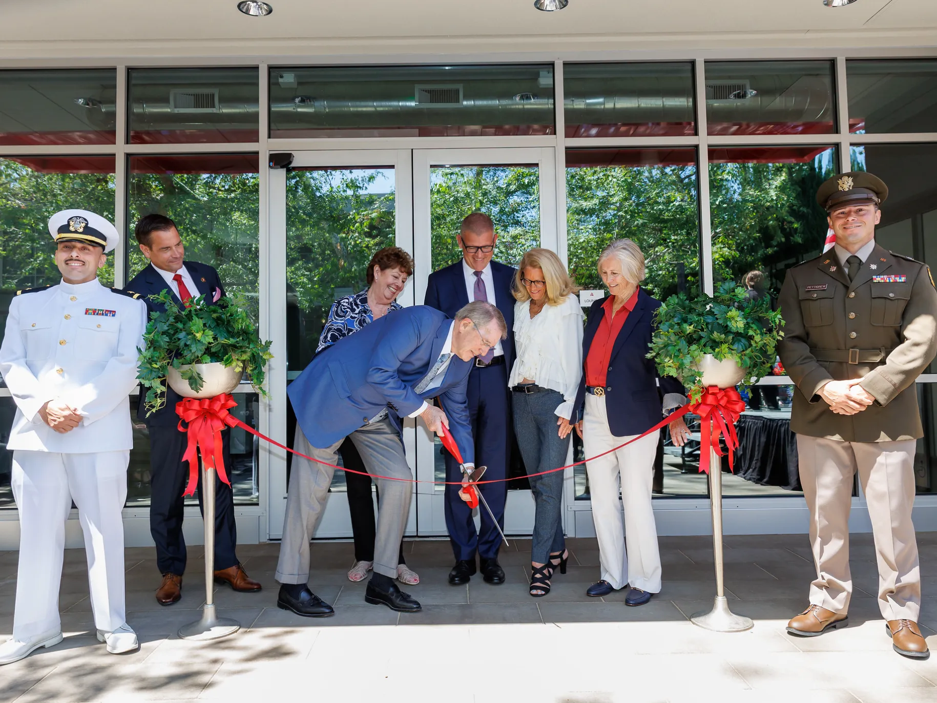 A man cuts a ribbon for the opening of APU's new Military and Veteran's Center.