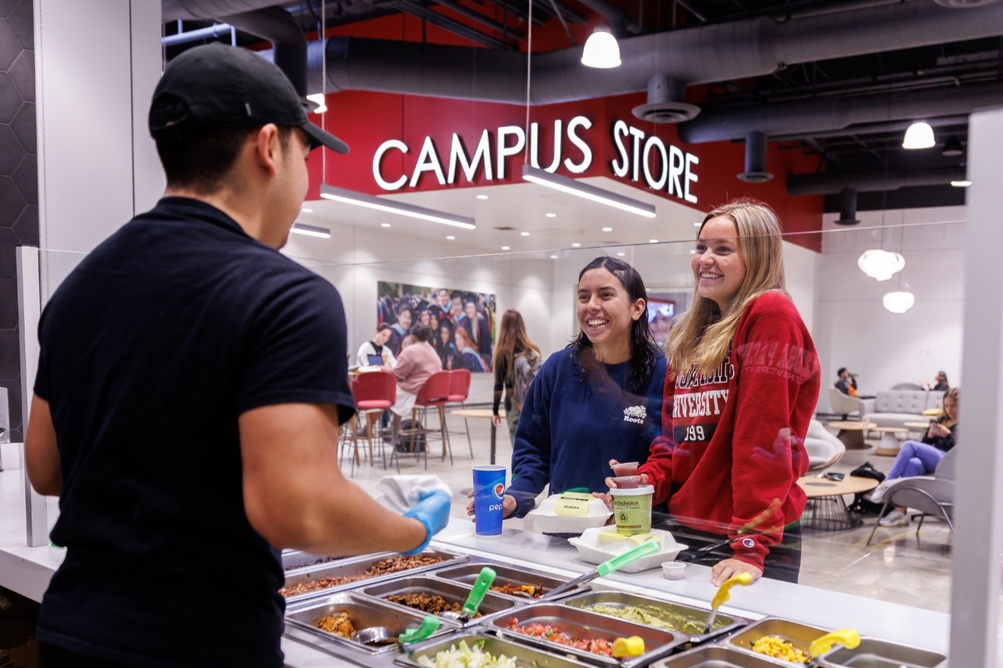 students converse with student worker at the cafeteria