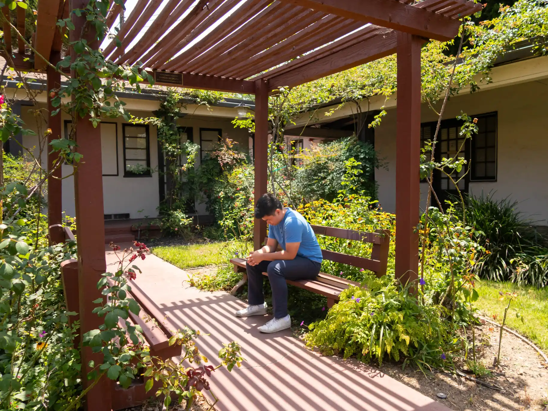 A student sits and prays in the Rose Garden.