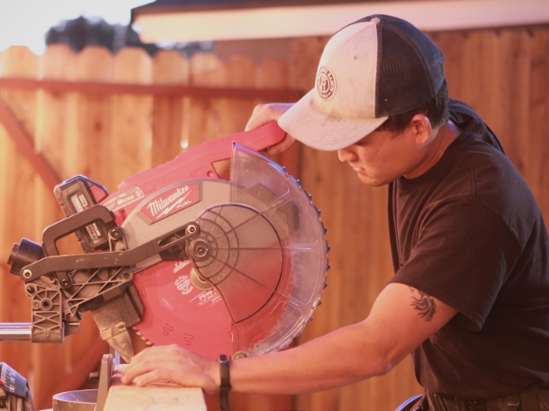 Taylor Mabuni cutting wood with a machine