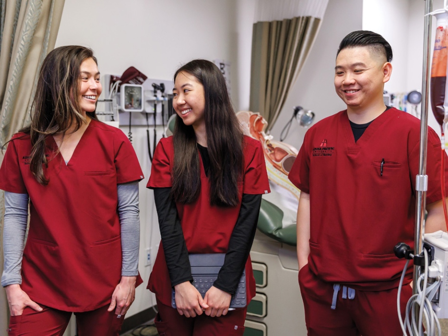 three nursing students smiling during class