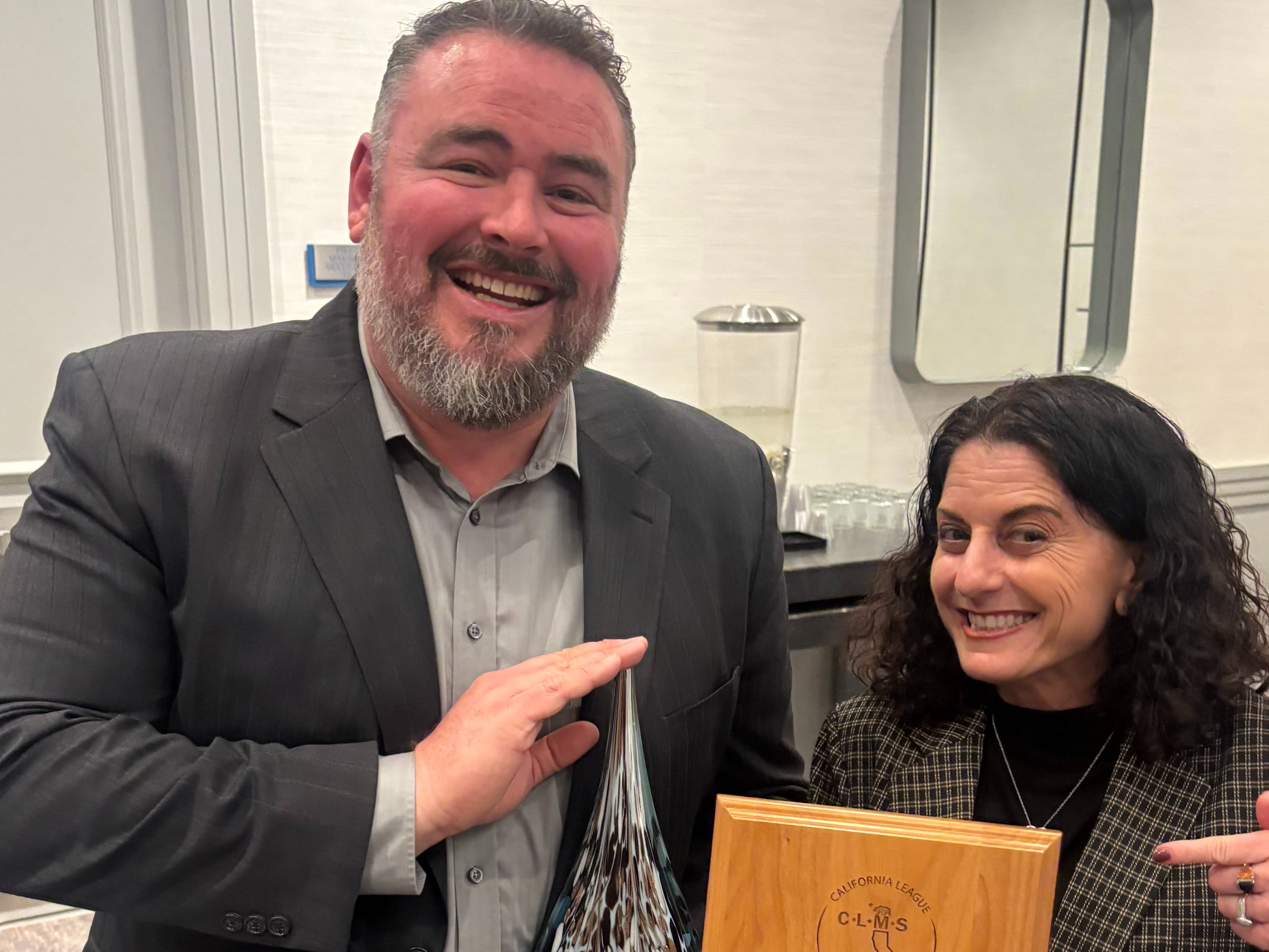 Man and Women holding awards smiling
