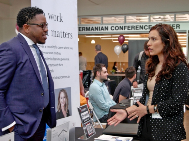 a man and woman wearing suits and speaking during an business event at apu