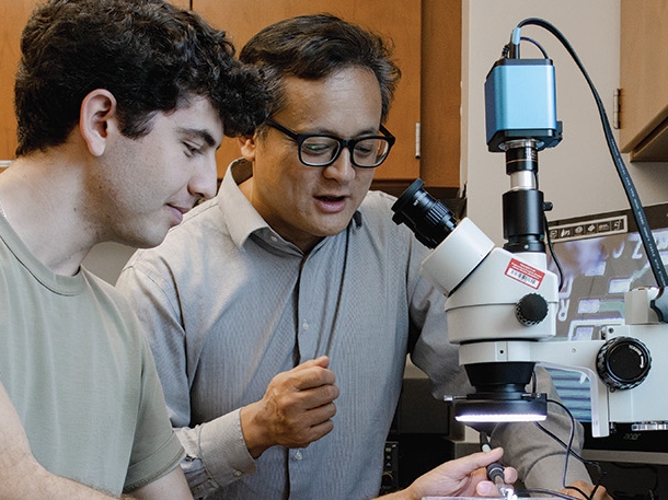 professor and students using a microscope