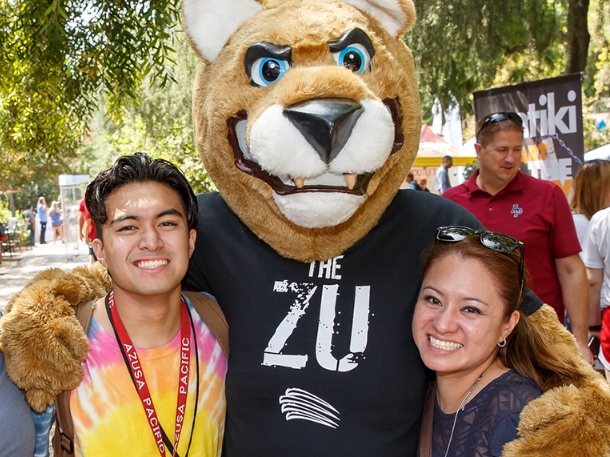 cougar mascot hugging family for a picture