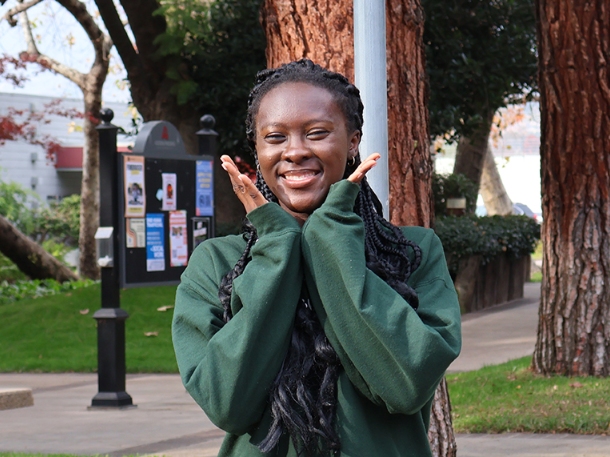 Madey Sule wearing green and smiling