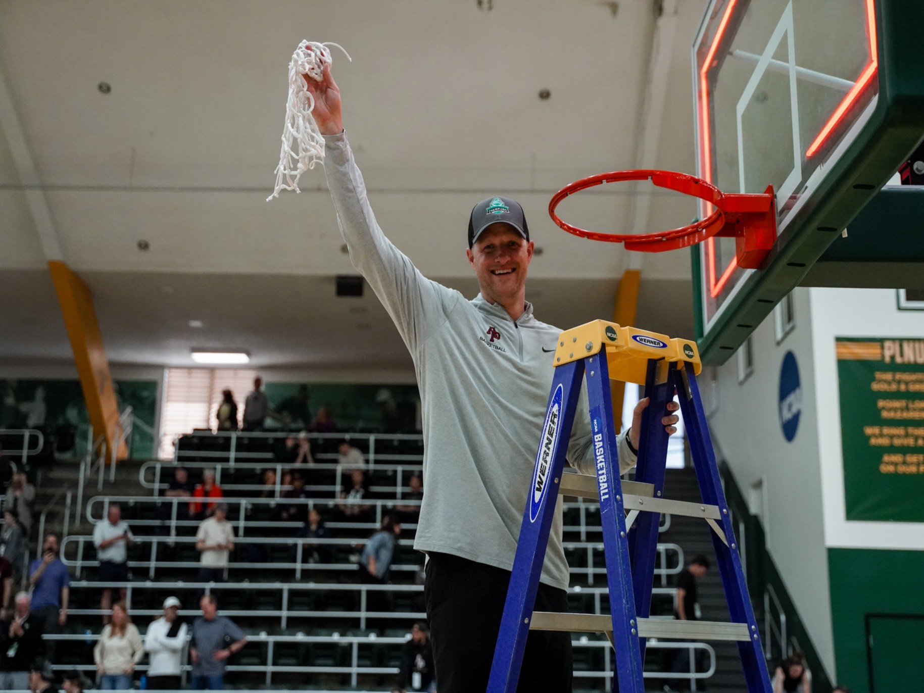 Peter on a ladder holding net of a basketball hoop