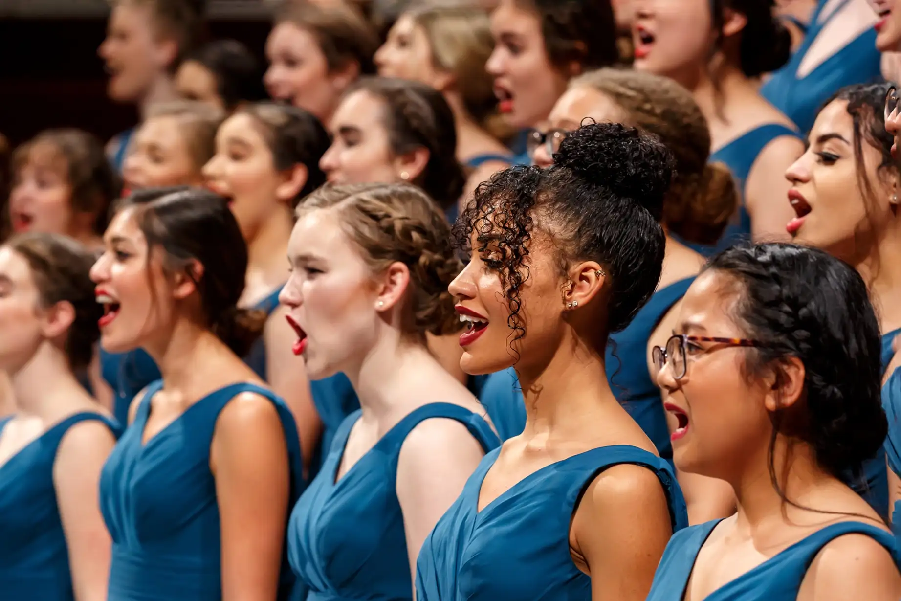 women's orchestra wearing blue dress and singing