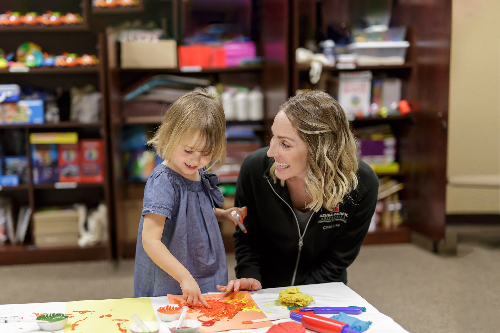 Student teaching a small child