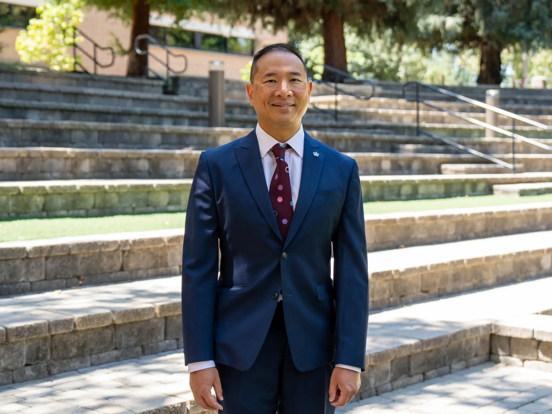 Enoch Hsu smiles in front of the Wynn Amphitheater steps.