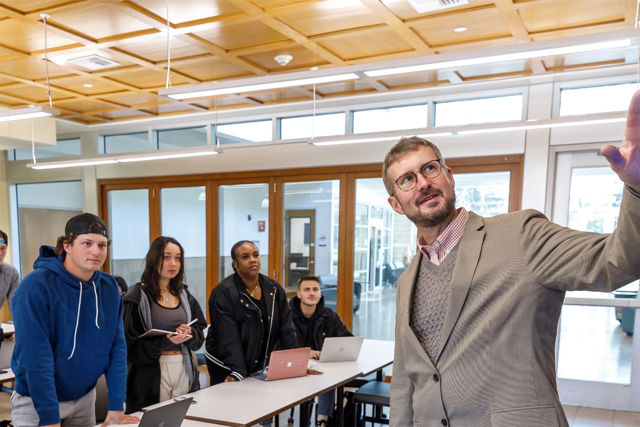 apu's professor explaining something to a group of students in the classroom