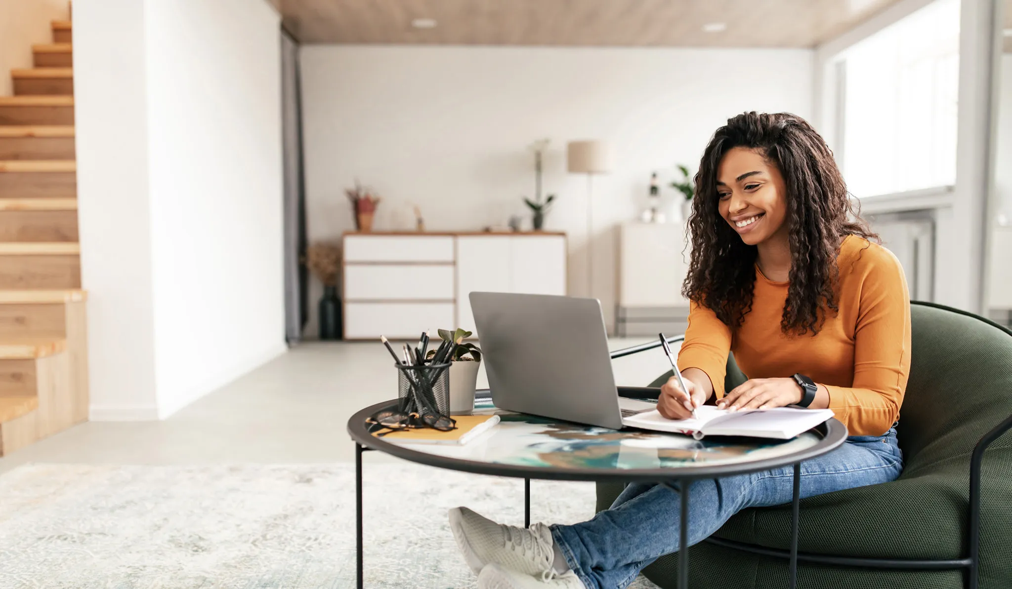 Online nursing student takes notes while studying on a laptop at home.  Select 88 more words to run Humanizer.