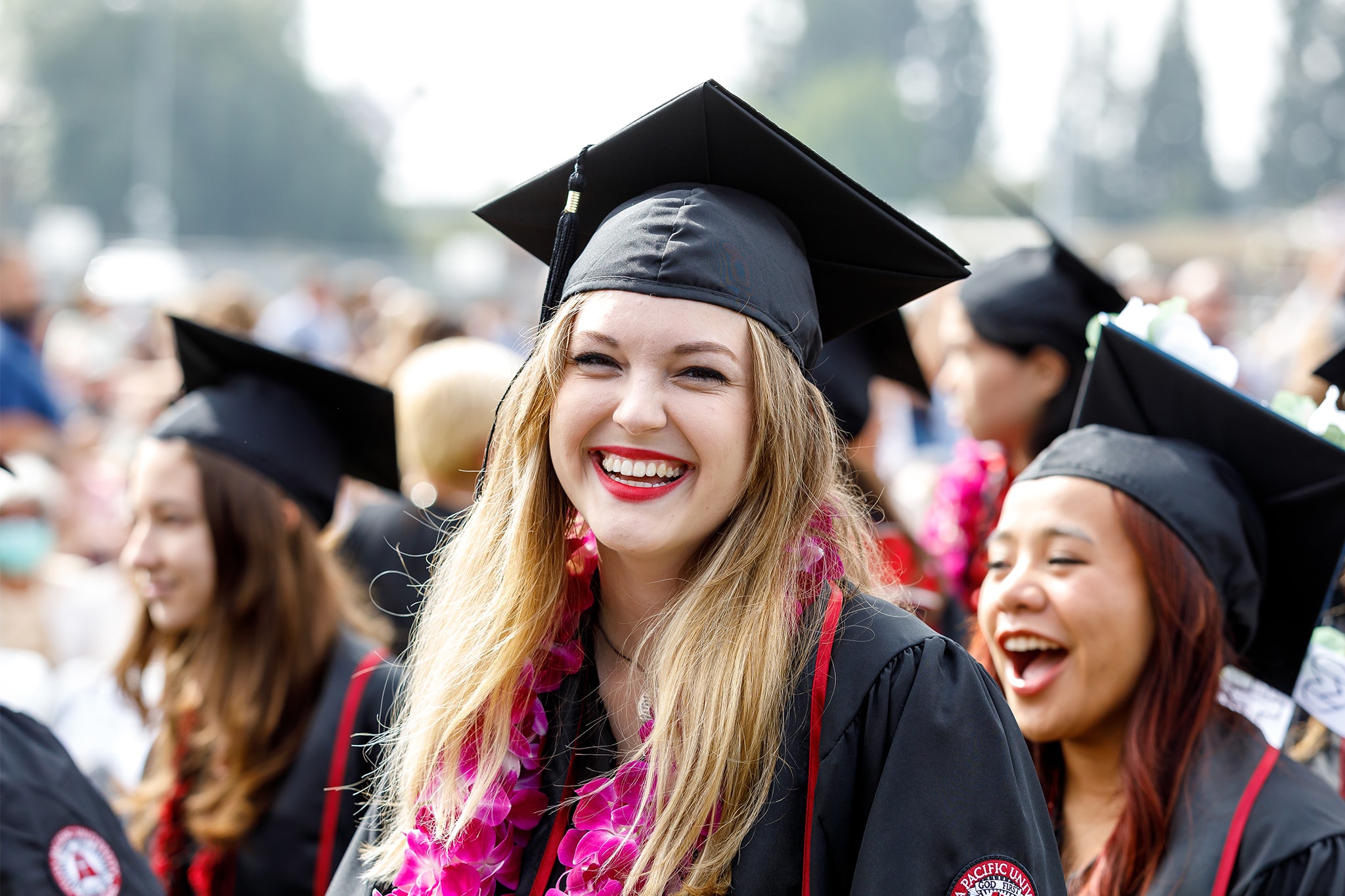 Student in cap and gown smiling