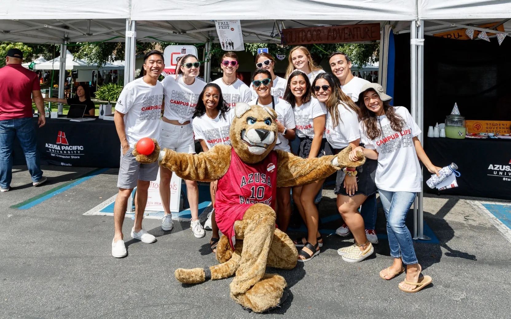 apu students smiling and gathering with cougar mascot during event